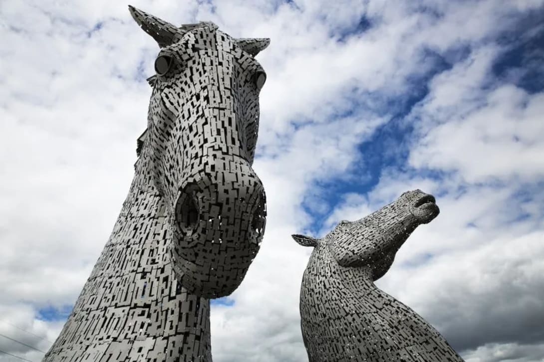 Close-up view of the towering Kelpies monument against a cloudy sky near Glasgow