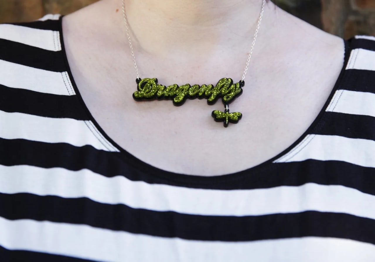 Close-up of a person wearing a dragonfly necklace during a Maxwell Park maternity session in Pollokshields