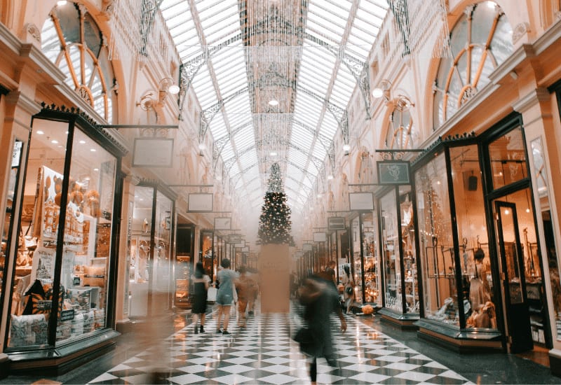 Shoppers walking through an arcade of small retail shops