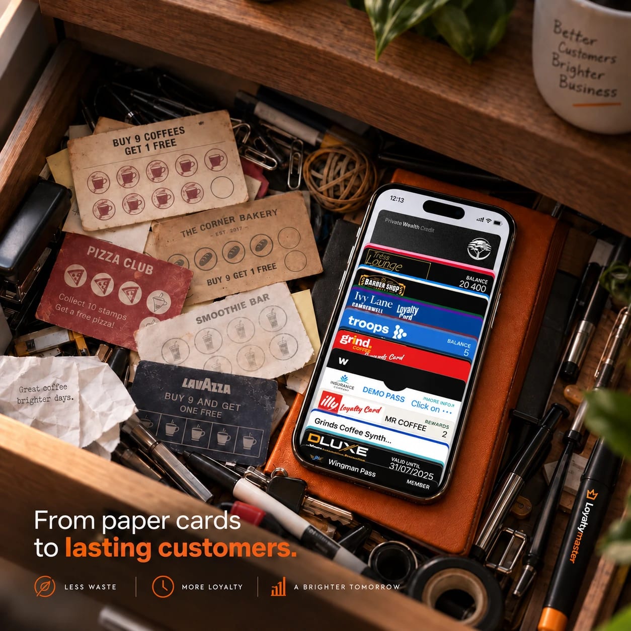 A drawer of worn paper stamp cards next to a phone holding a stack of digital loyalty cards in its wallet