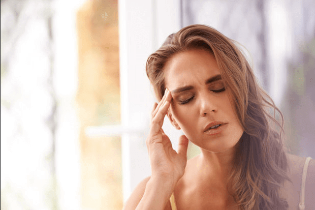 Woman holding head indicating she has a headache