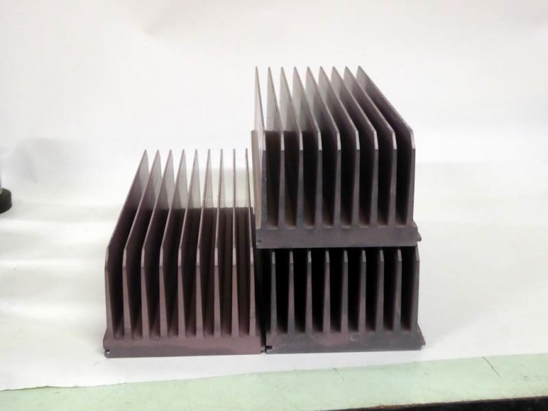 Hi-tech, large, extruded, anodised aluminium heat sink shapes with long fins.