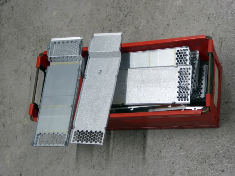 Honeycomb pierced shaped metal pieces in red fibre board tray