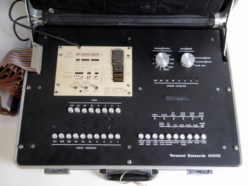 Black suitcase with technical control panel, chunky rainbow ribbon cable, buttons, LEDs etc