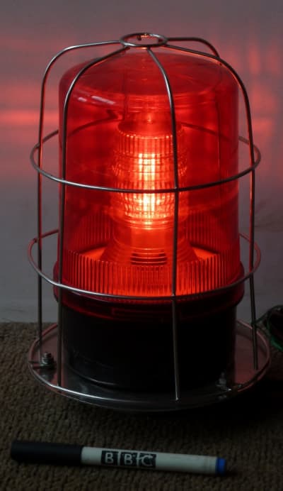 Caged red industrial warning beacon