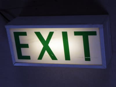 Practical period emergency exit sign, green backlit lettering