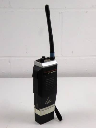 Large, bulky 1980s walkie-talkie radio with optional shoulder case & vehicle charger cradle