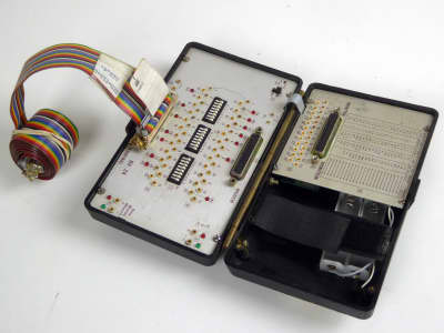 Wandel & Goltermann clamshell RS232 interface tester with rainbow ribbon cable, LEDs & tiny switches