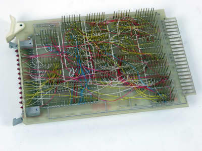 Computer chips on circuit board with gold tines & complex wiring on rear