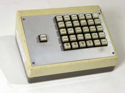 Small sloping desktop console with 5x6 matrix of square buttons