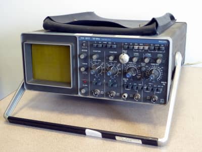 Grey 1980s laboratory oscilloscope with numerous knobs & buttons