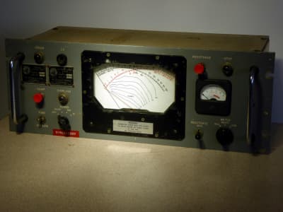 Battleship grey cold war era control panel with twin needles meter, lamps & knobs