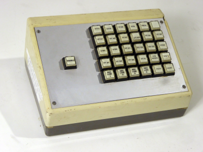 Small sloping desktop console with 5x6 matrix of square buttons