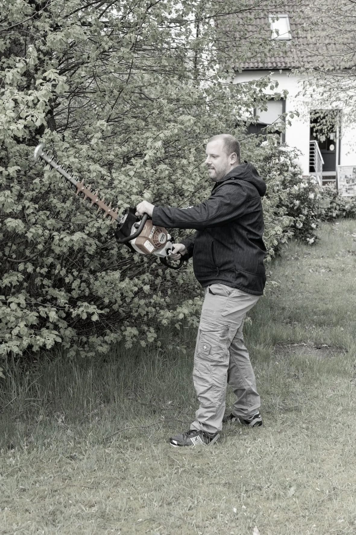 Steffen Arndt beim Heckenschnitt mit der Heckenschere im Garten