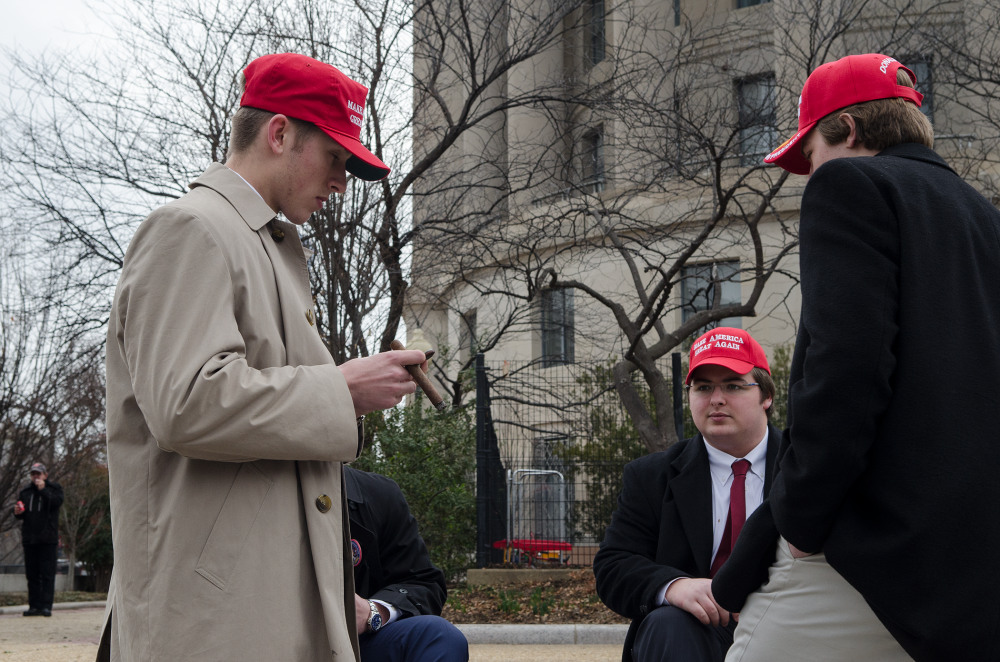 Young men wearing red hats engaged in conversation outdoors