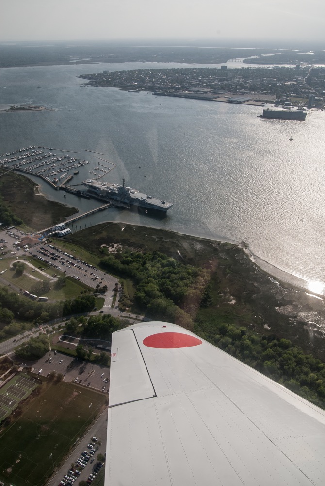 Aerial view of a coastal city with a harbor and parked boats