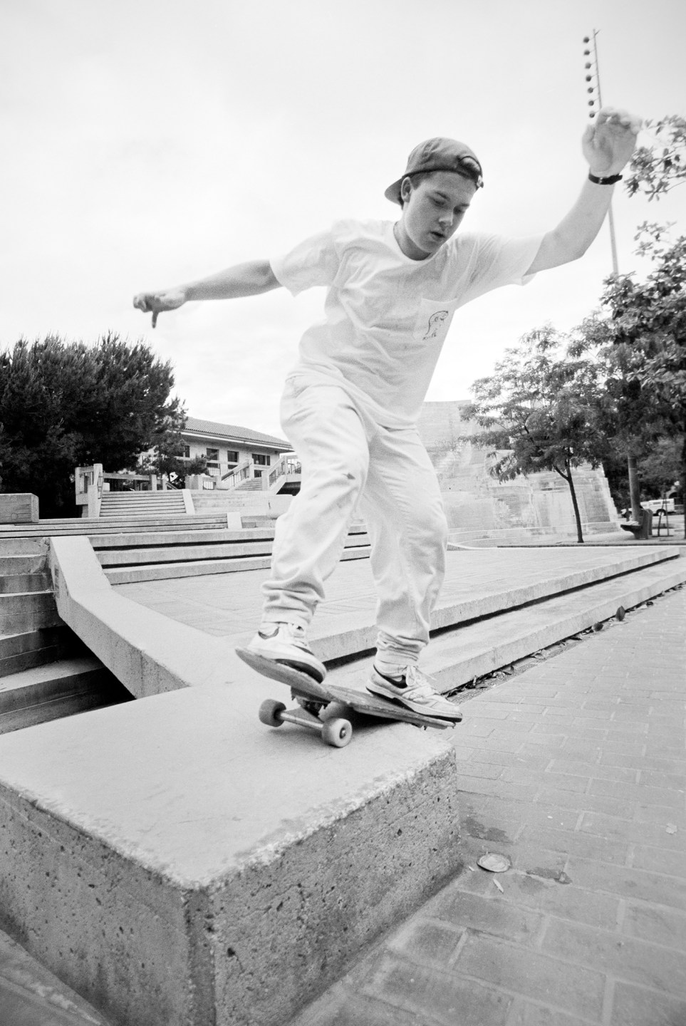 Skateboarder performing a trick on a concrete ledge in a park setting
