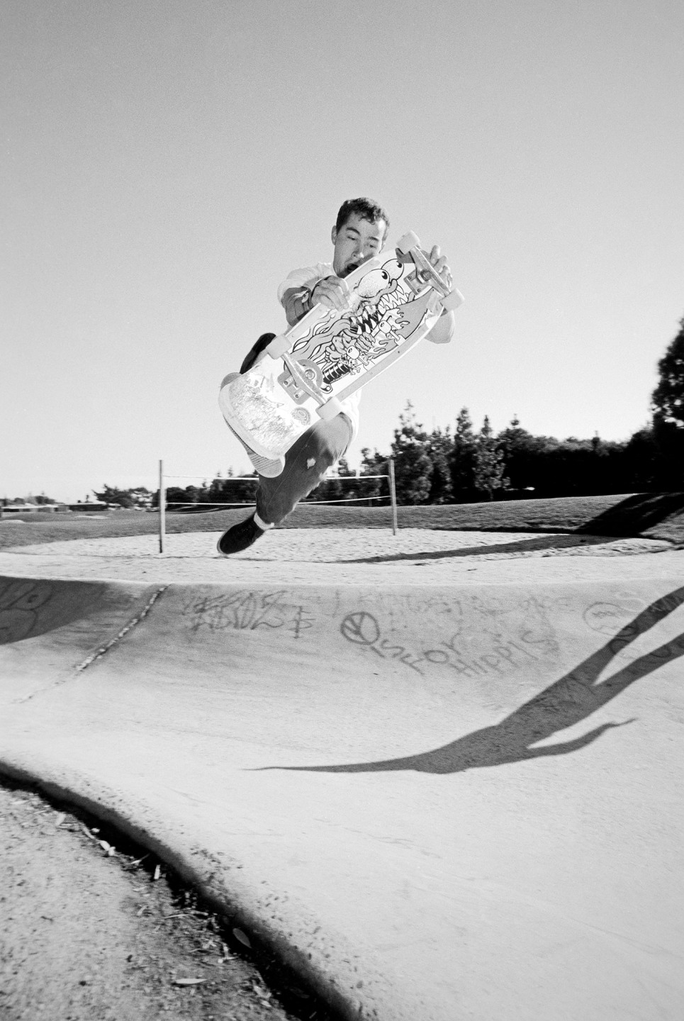 Skateboarder airborne over a concrete ramp in a black and white setting