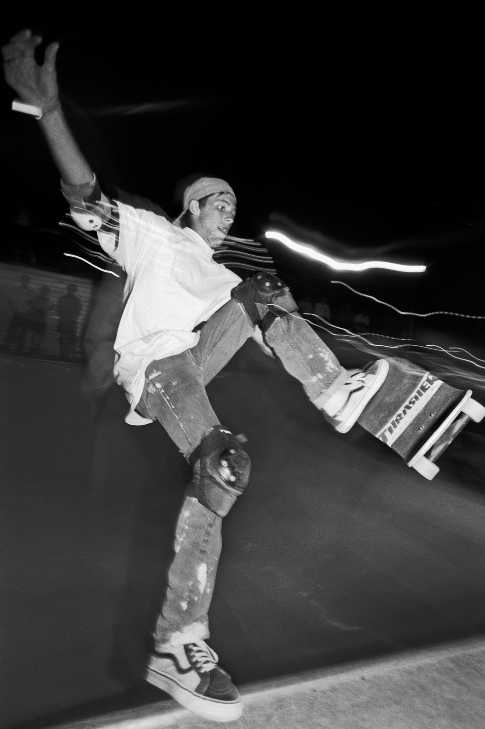 Skateboarder performing a trick in a skatepark at night