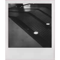 Abstract black and white image featuring angled lines and circular lights