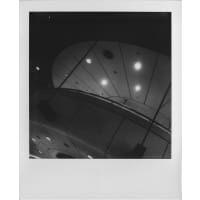 Abstract black and white image of a modern ceiling with circular lights and smooth curves