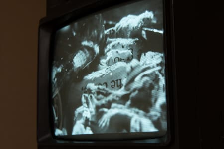 A vintage black-and-white television displaying a distorted image of objects