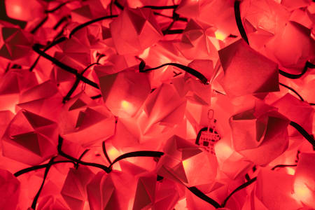 A close-up of red decorative lights resembling origami shapes