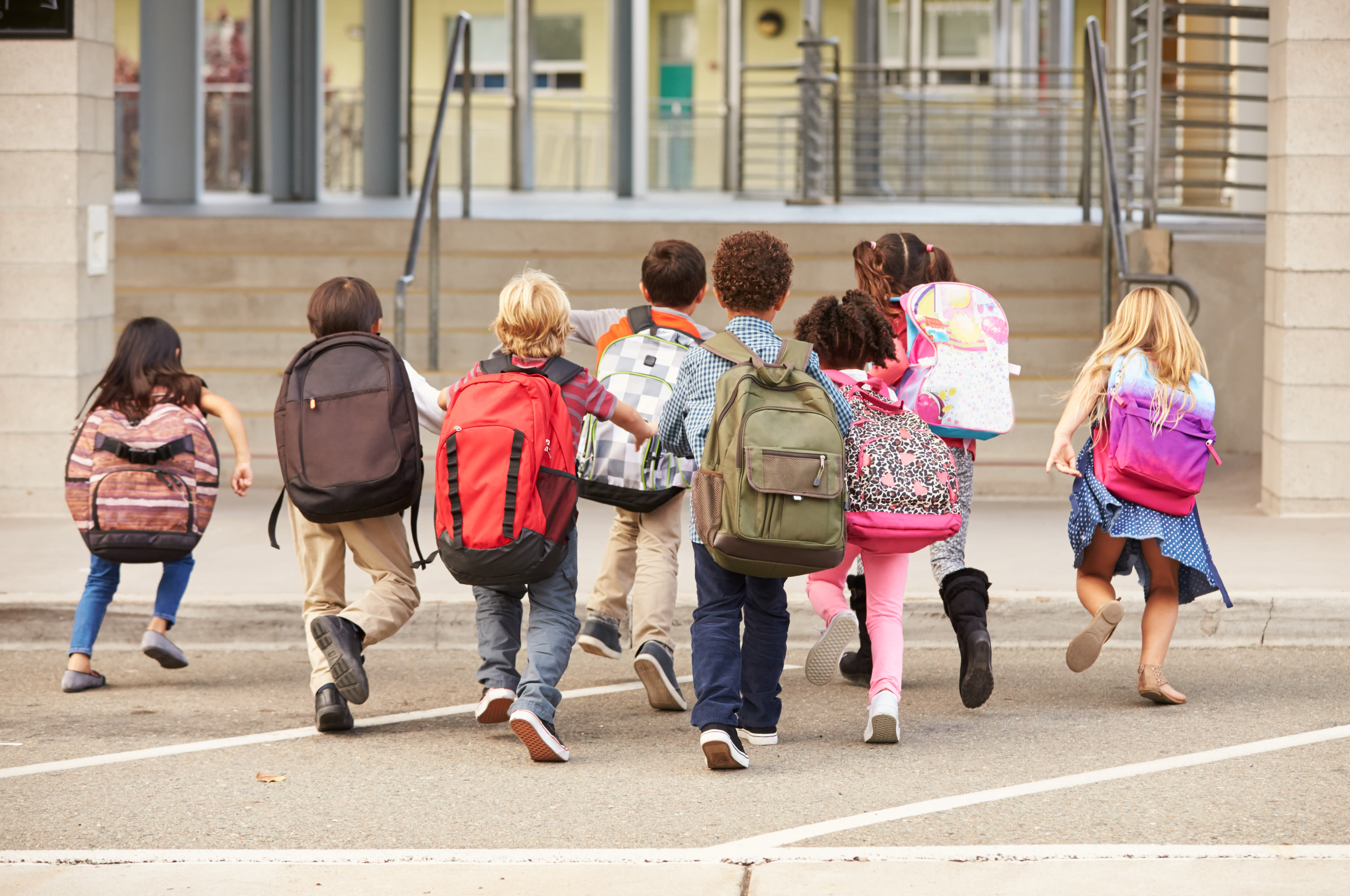 Gruppe barn som løper mot skolen