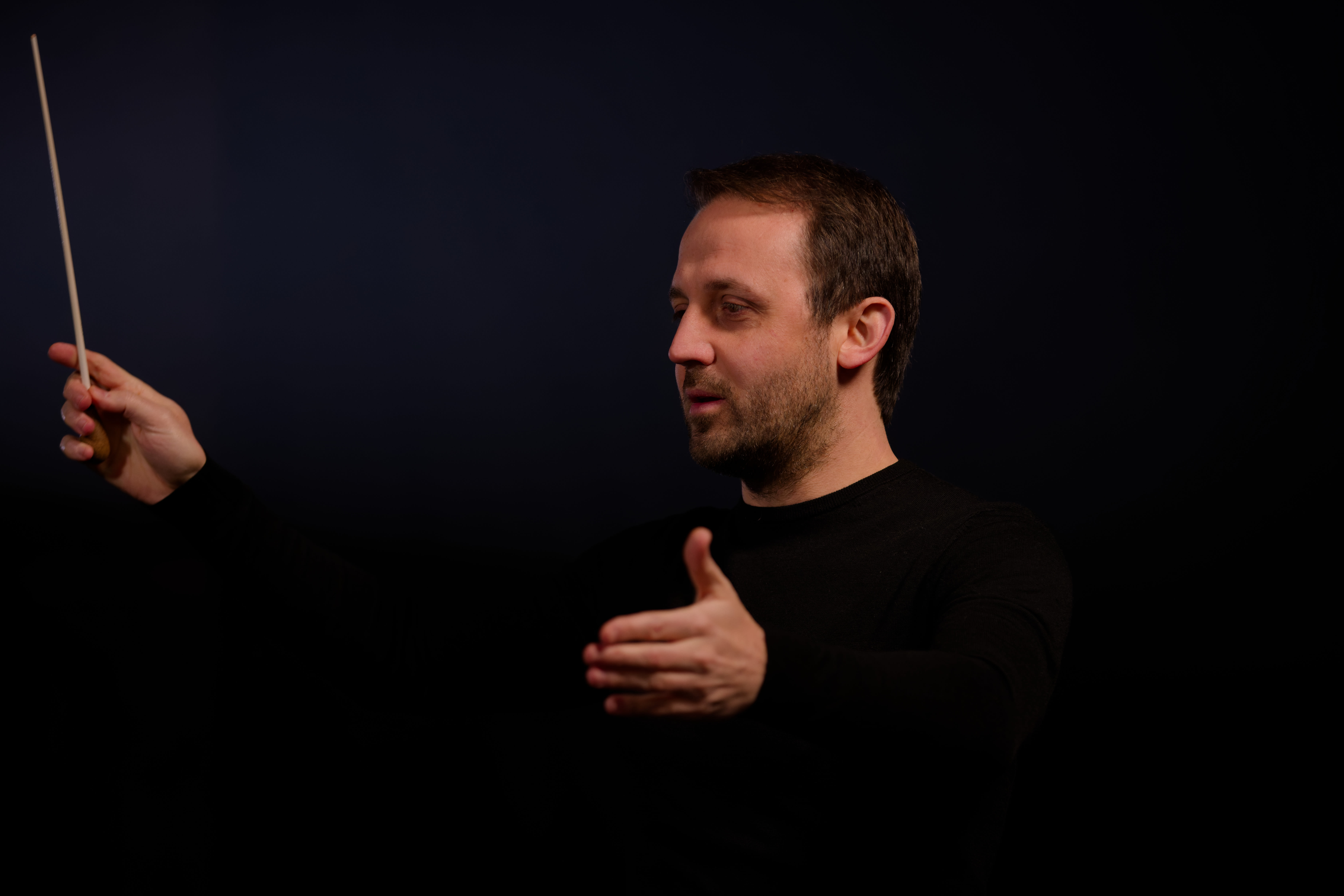 Luigi Mazzocchi conducting an orchestra during a symphonic concert