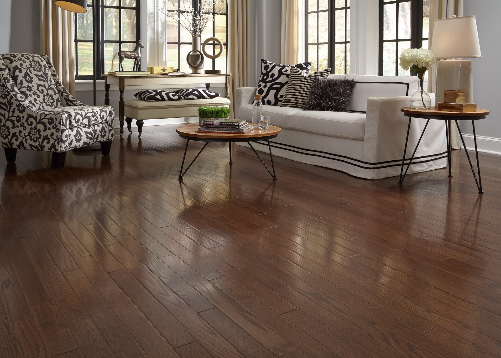 This well appointed living room with a couch and metal horse figurine features Builder's Pride Mocha Oak Solid Hardwood Flooring