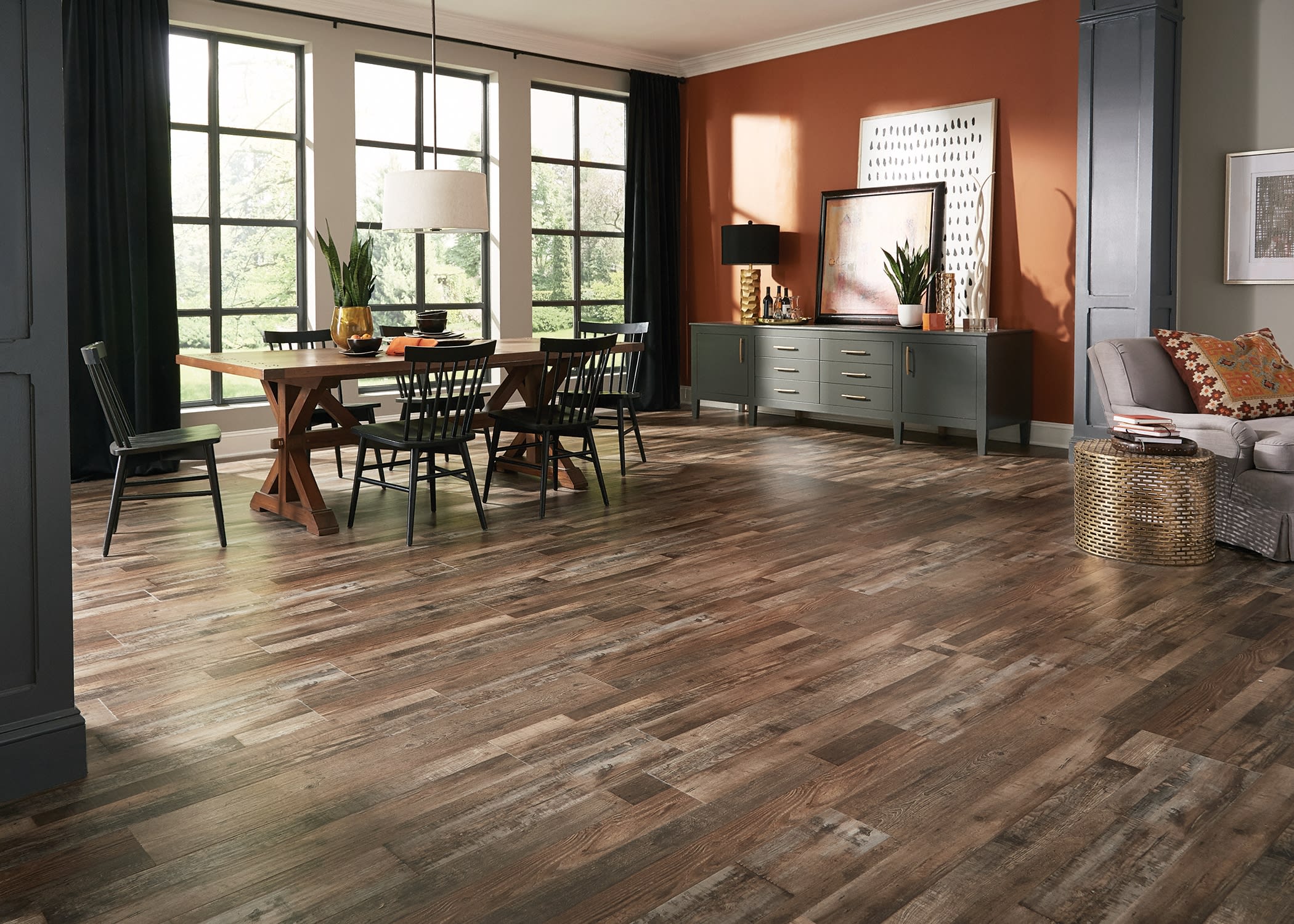 living room with an orange wall, gray columns, and vinyl plank flooring