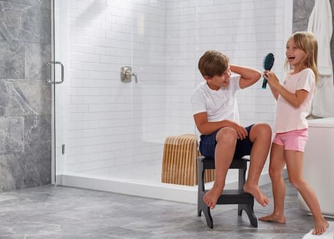 kids play in a bathroom with porcelain wall and flooring tile and subway tiles in the shower