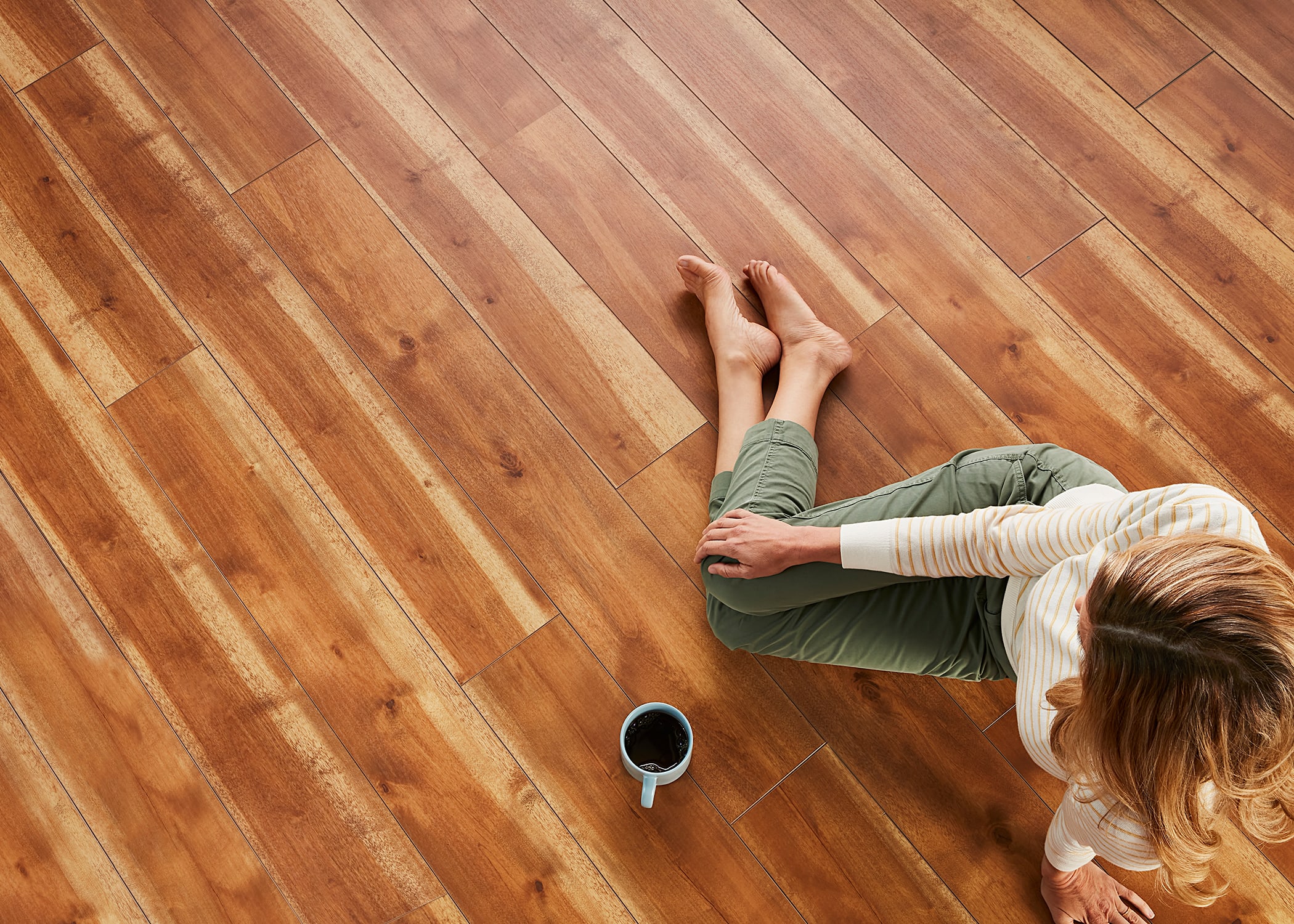 a woman sits on a vinyl plank floor