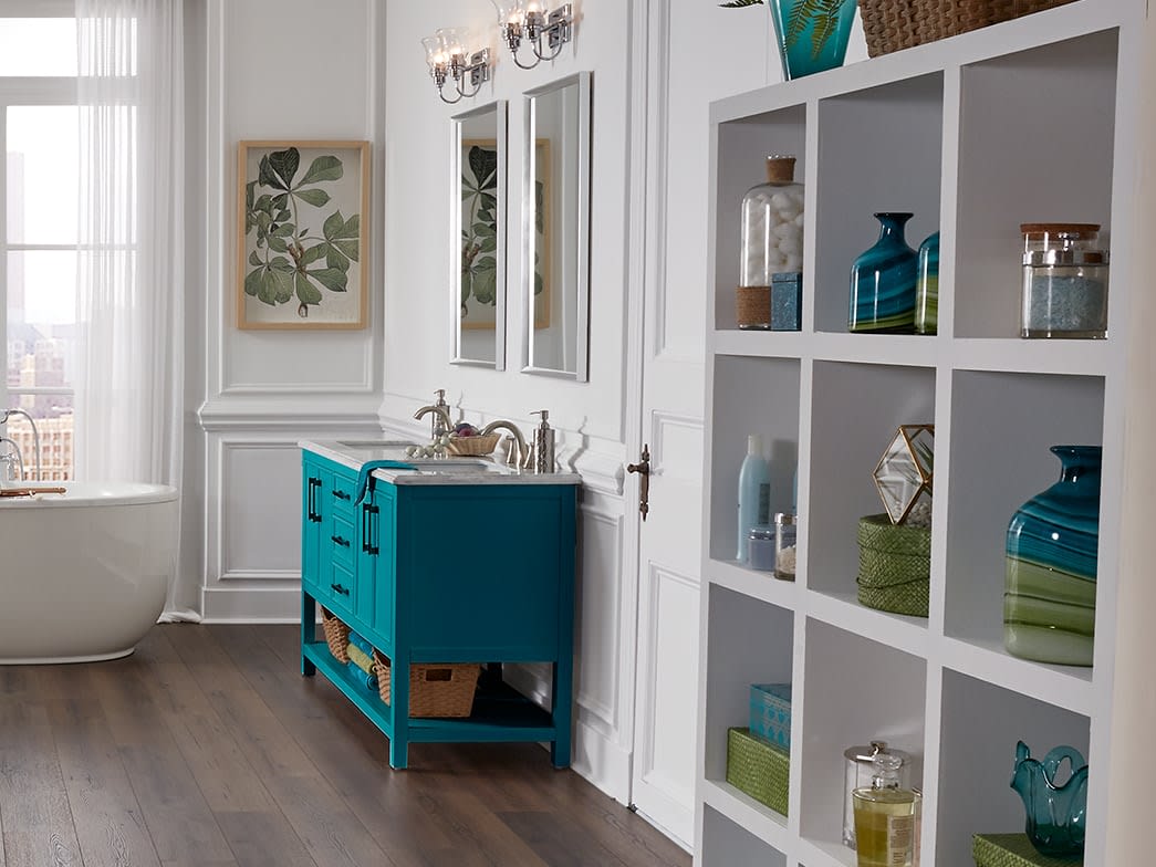 Glasswear and blue and green decor in this white shelving adds color and energy to this stylish bathroom.