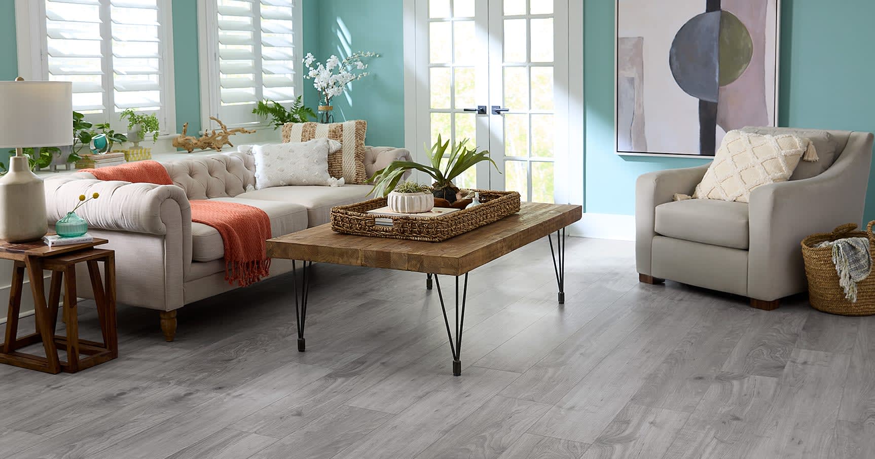 This lively living room achieves a fresh balance, with bright color decor & paint to play with the stylish neutral gray wood flooring (Rigid Vinyl Plank).