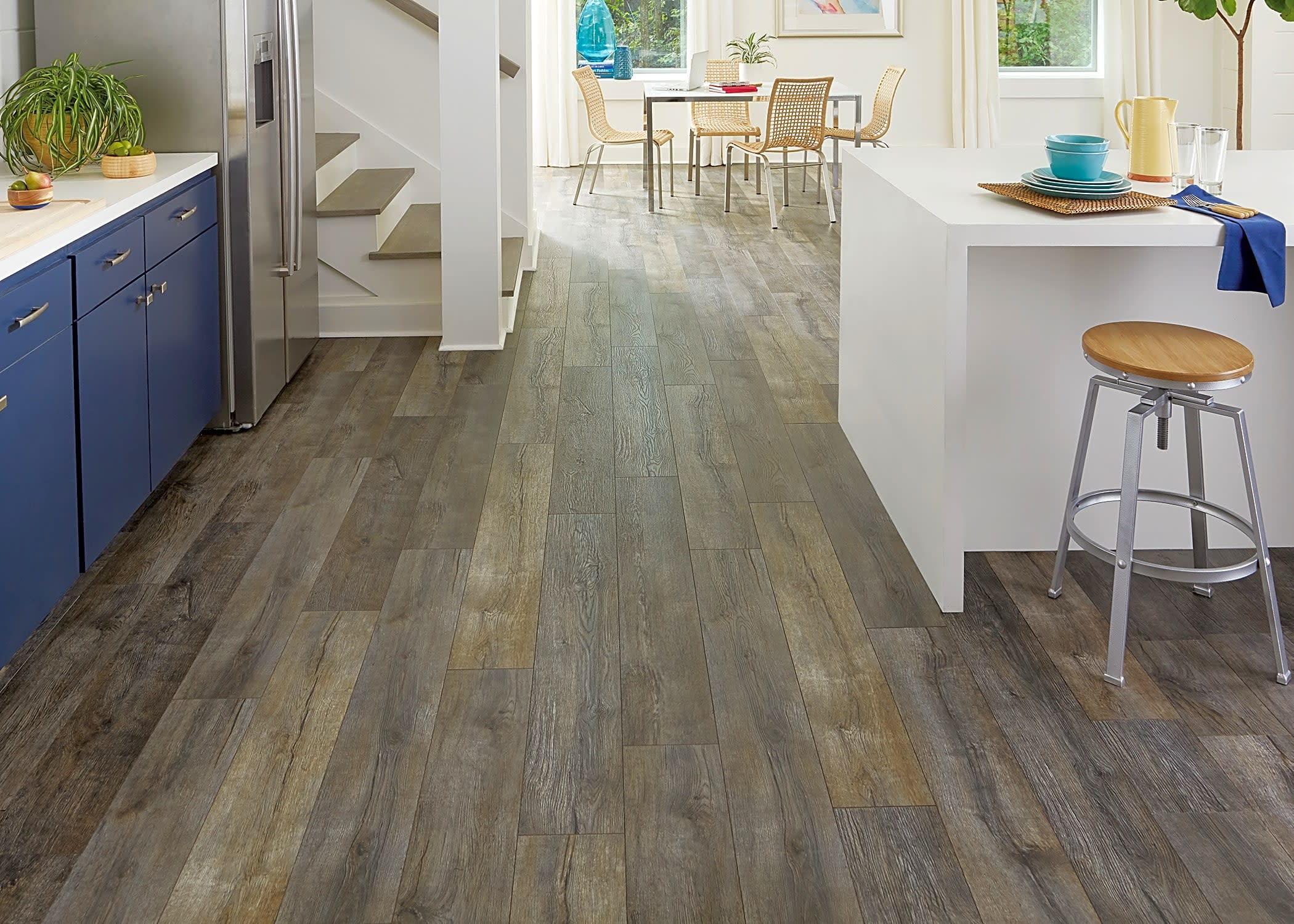 This lively, modern kitchen features Dream Home Shadow Sail Oak Waterproof Laminate Flooring.