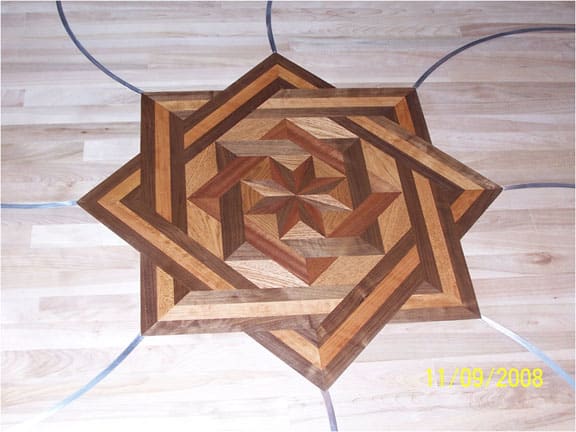 Detail of a Hickory floor with a medallion, aluminum, and granite.