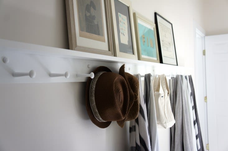 This entryway uses wall pegs for coats and hats