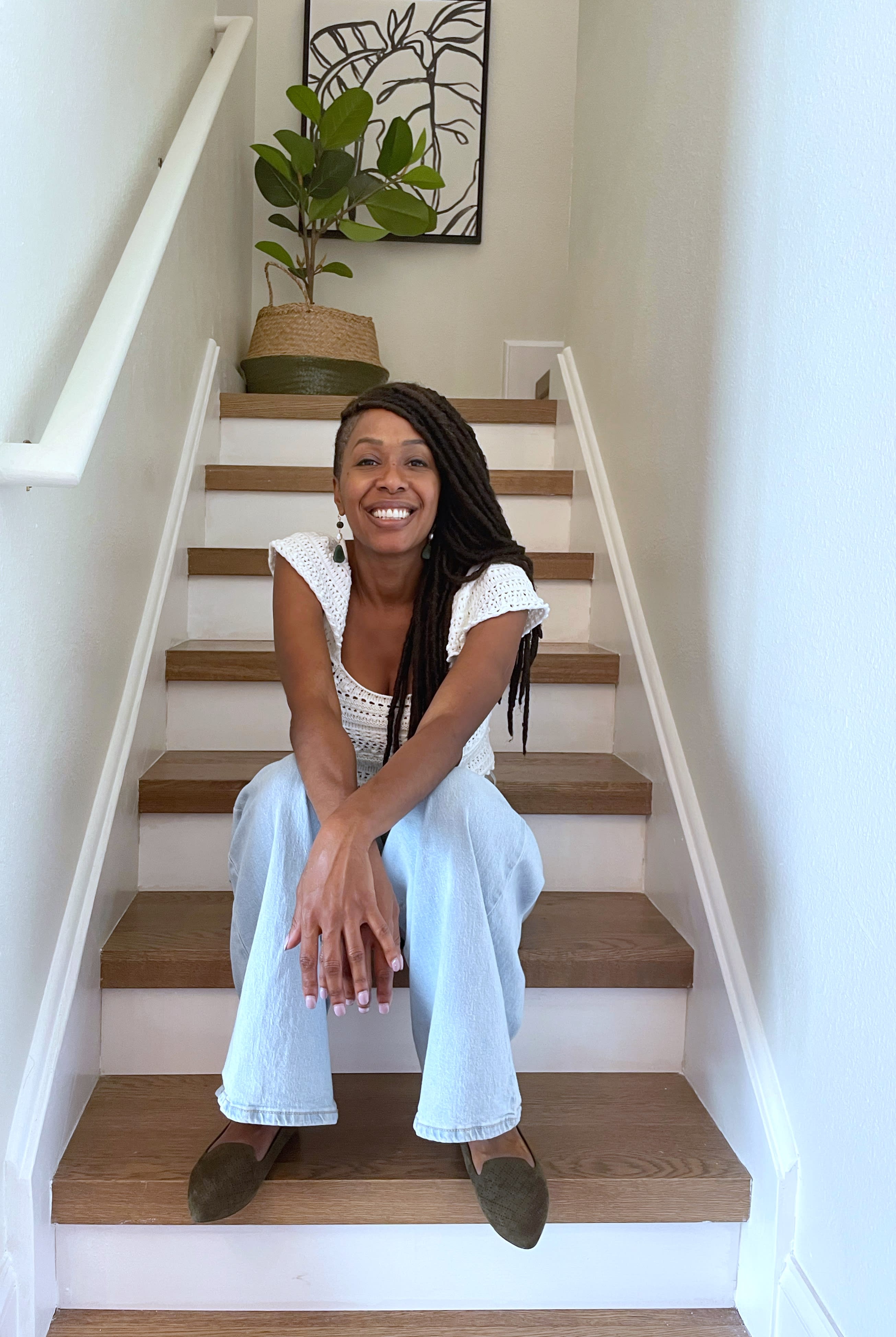 kay volmar smiles as she sits in a home's stairway