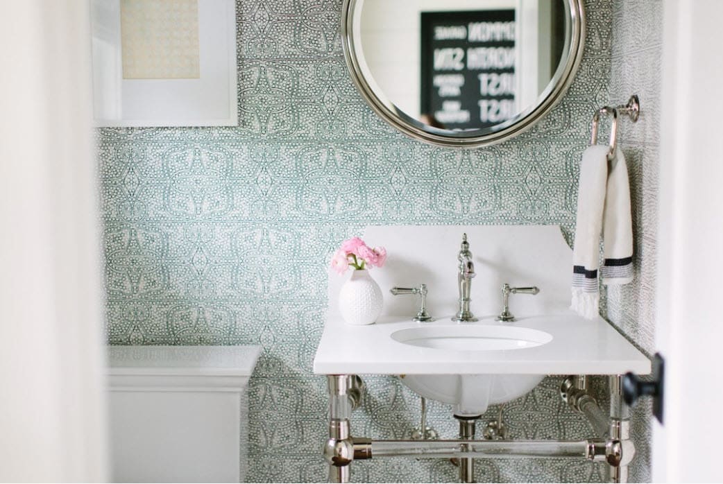 This small bathroom with white sink is made larger in appearance by using green patterned wallpaperThis mid century modern bathroom features white subway tiles.