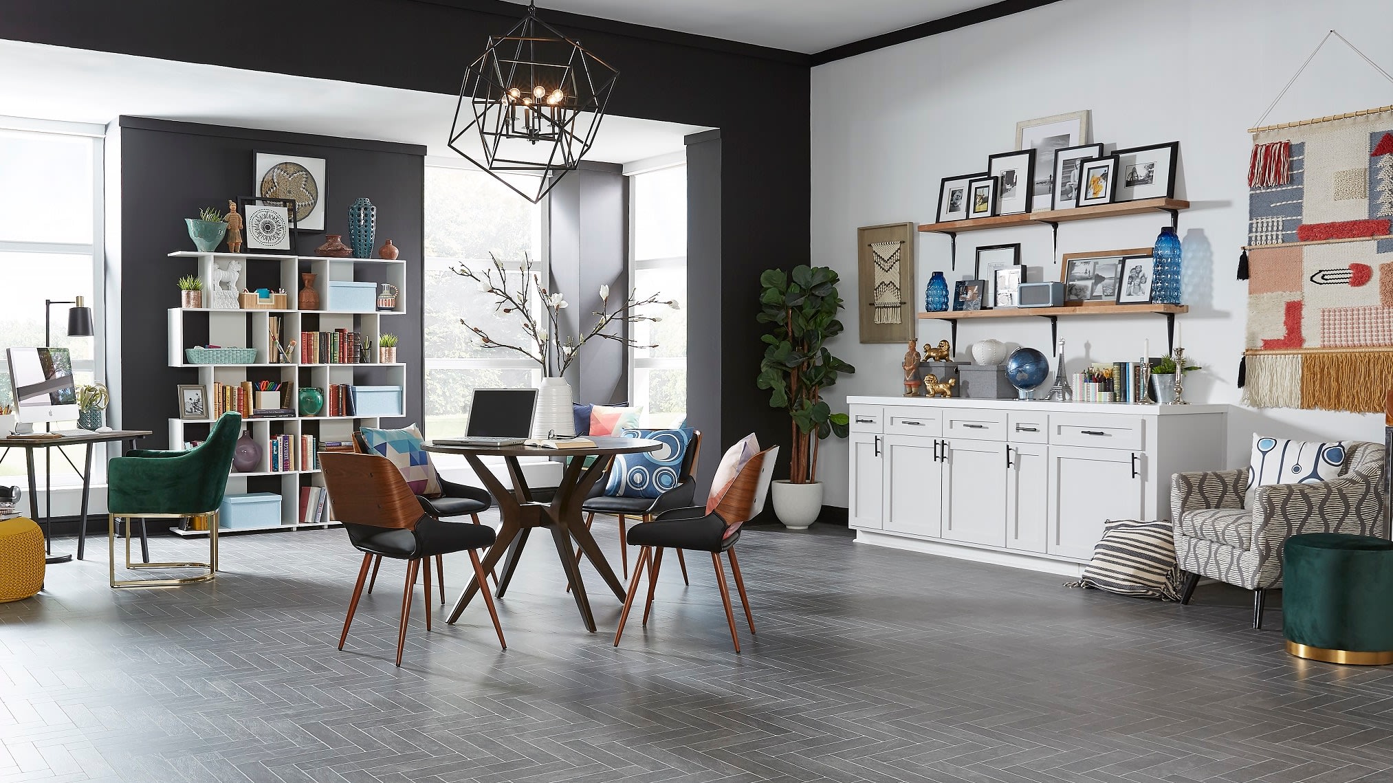 This open plan dining room and study features maximalist style, with found objects, art, and personal effects as decor. Neutral flooring is Burgess Gray Brick 24 Hour Water-Resistant Laminate.