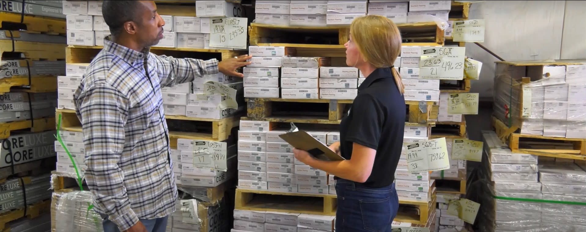 A contractor and store associate discuss flooring needs at an LL Flooring store.