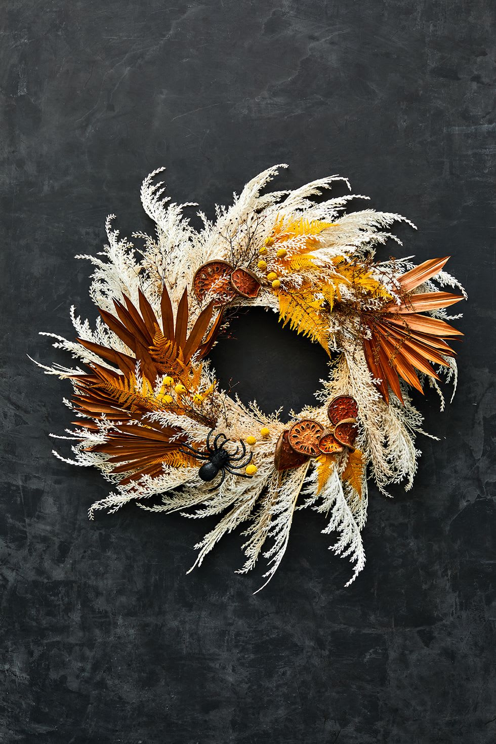 autumn wreath made of dried flowers with flares of orange color