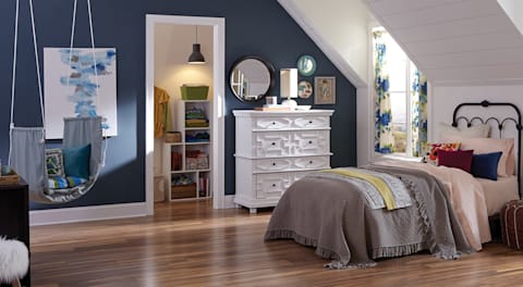 bedroom with a neatly organized closet and waterproof laminate flooring