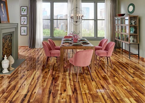 12mm Heard County Hickory High Gloss Laminate Flooring in dining room with wood dining table and blush velvet chairs plus sage green painted fireplace and black orb chandelier