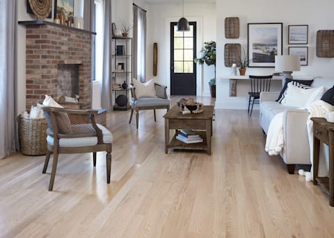 This modern-mission inspired living area shows wicker accents, dark wood furnishings, and a light feel from character-grade Character Red Oak Solid Hardwood Flooring.