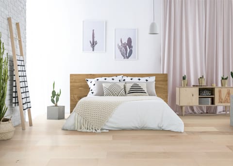 Light, neutral color accents and Gander Downs Maple Engineered Hardwood Flooring decorate this bedroom.