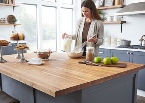 This kitchen is a chef's dream with a wide preparation surface on a sleek butcher block island top.