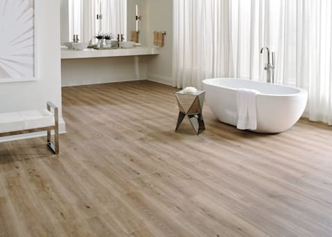 7mm+Pad Lake Worth Oak Hybrid Resilient Flooring in bathroom with oval freestanding bathtub and floating vanity