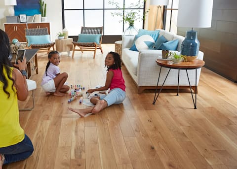 a family plays on a solid hardwood floor